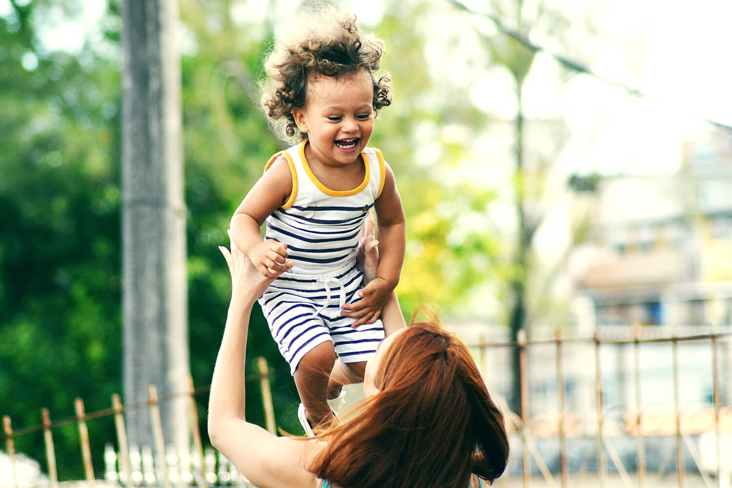 A parent plays with a giggling toddler