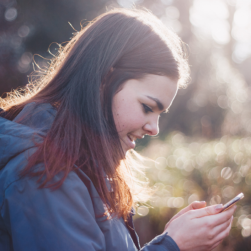 teen looking at mobile phone